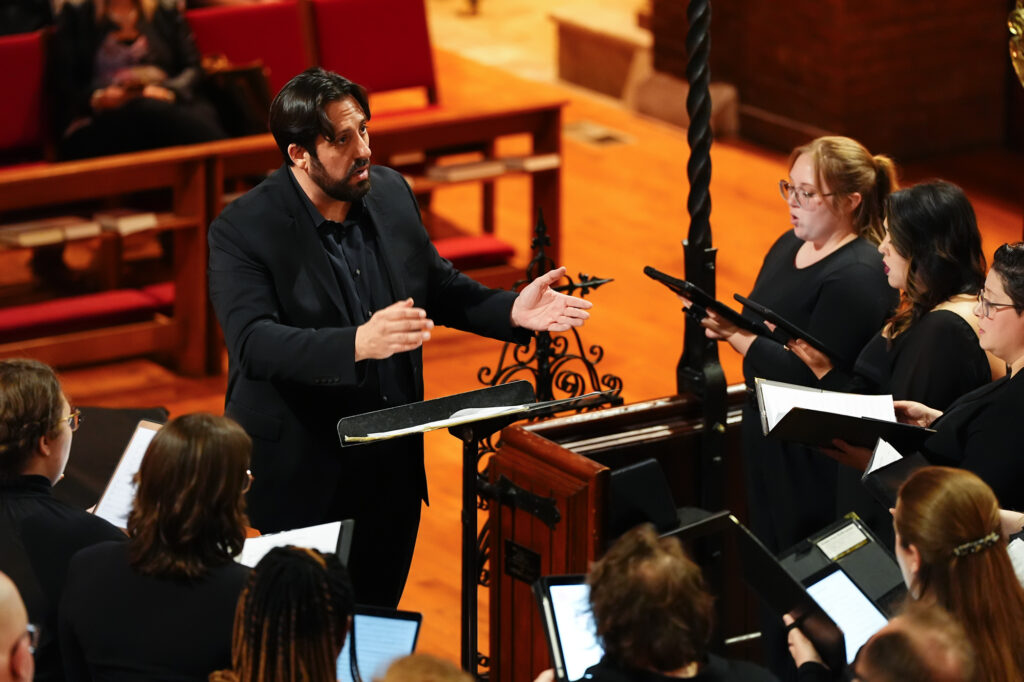 Dr. Anthony Maglione, Director of Choral Studies, conducting singers during a Cardinalis choir performance.
