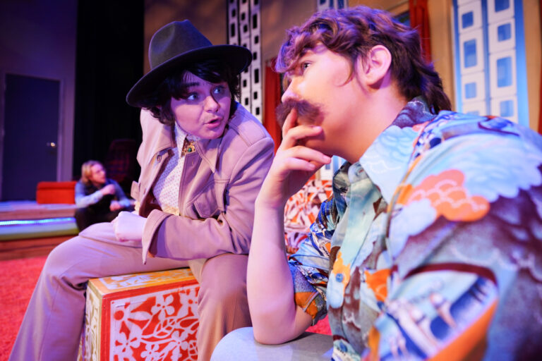 Close-up of 2 student actors in retro costumes conversing on stage during a Jewell Theatre Company production of "The Inspector General."
