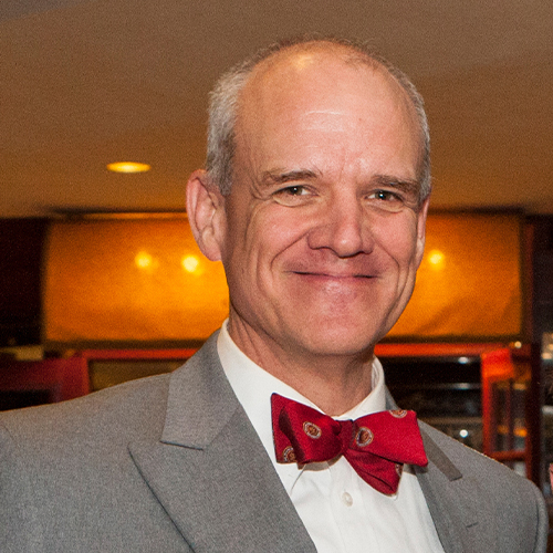 Headshot of Dr. Gary Armstrong, Professor of Political Science; Oxbridge Institutions and Policy Coordinator and Adviser at William Jewell College, wearing a gray suit jacket and a red bow tie.