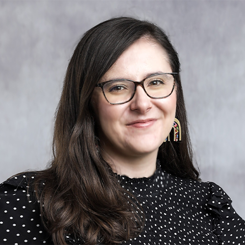 Headshot of Jacqueline Land, Assistant Professor of Communication at William Jewell College, wearing glasses and a black-and-white polka dot top against a gray backdrop.