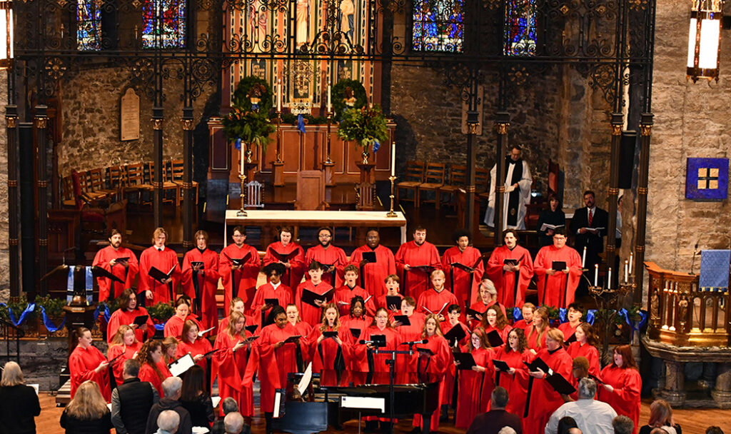 The William Jewell College choir performing inside a historic church sanctuary with stained glass windows.