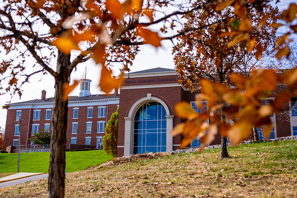 Pryor Learning Commons and Jewell Hall framed by autumn leaves.