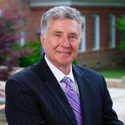 Headshot of Dr. Drew Van Horn, President of William Jewell College, wearing a dark pinstripe suit and purple striped tie.