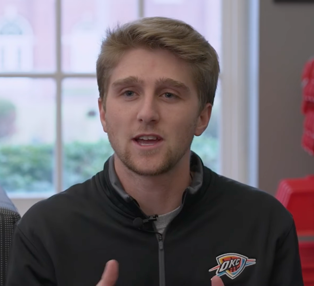 Bennet Williams, a business student at William Jewell College wearing a black quarter-zip, speaking in a student spotlight video.
