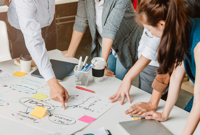 Business professionals collaborating on a strategy diagram during a team meeting.