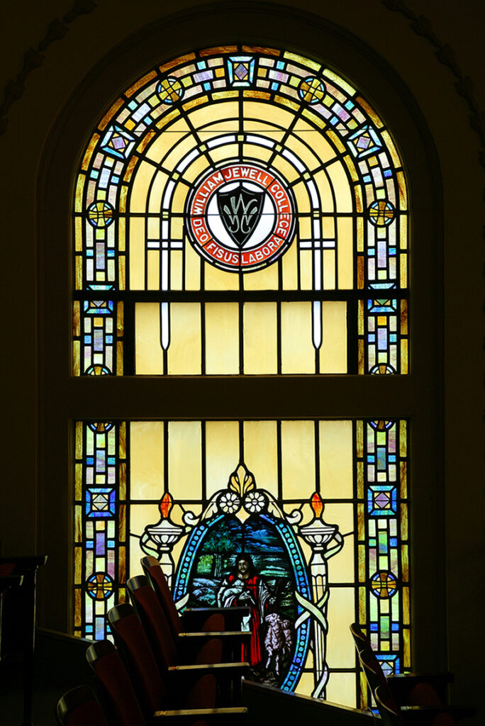 An interior view of the detailed stained-glass window inside John Gano Memorial Chapel featuring the William Jewell College seal.