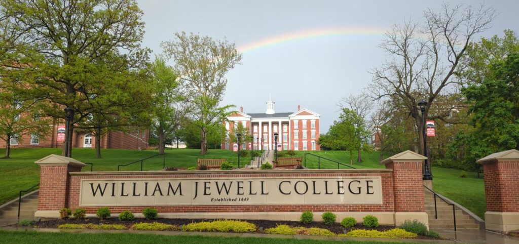 Jewell Hall on a hill with rainbow behind it