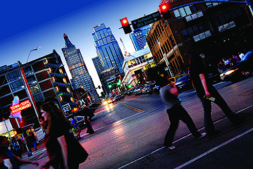 pedestrians crossing busy downtown metropolitan street