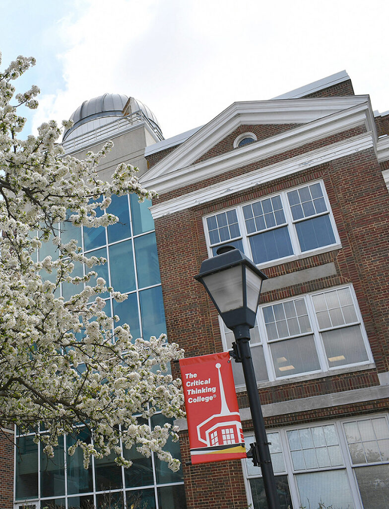Exterior of science building in spring with The Critical Thinking College banner