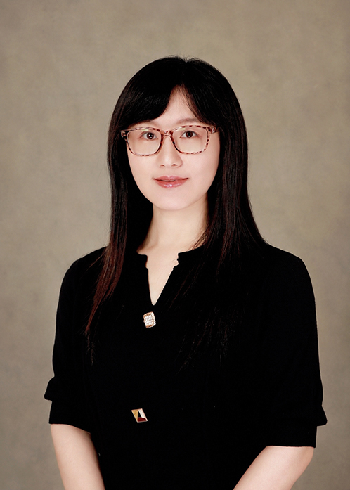 Ge Zhu, Assistant Professor of Communication, wearing tortoise-shell glasses and a black top in a studio headshot.