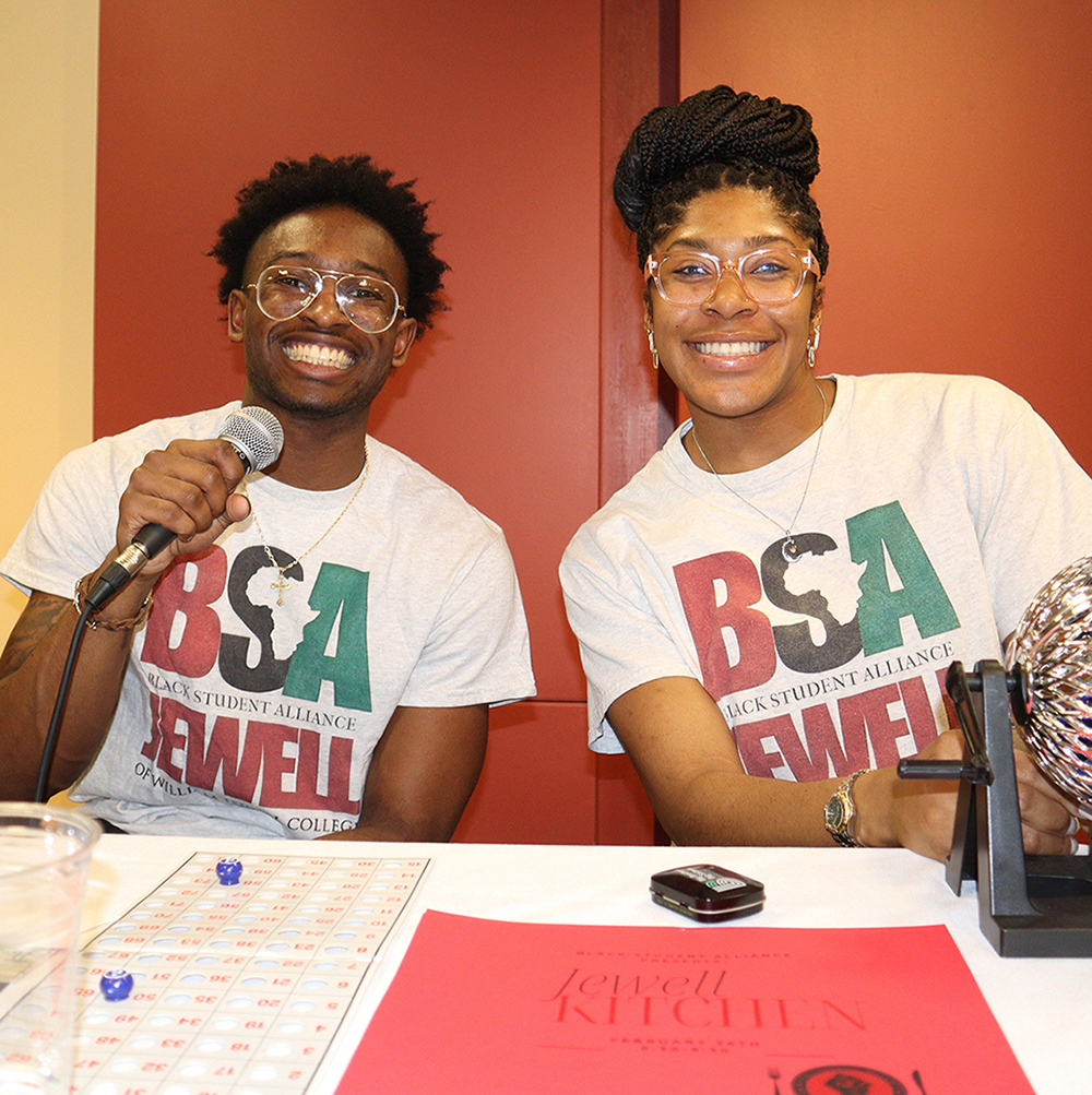 2 students wearing Black Student Association shirts with microphone hosting event