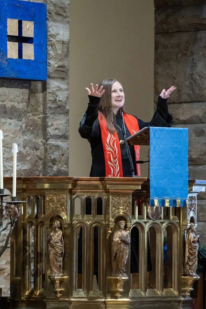 Jewell chaplain at podium in a cathedral, speaking to crowd
