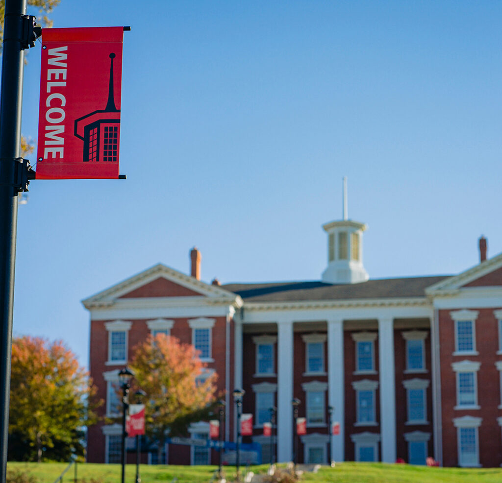 pole banner reading WELCOME with Jewell Hall in background