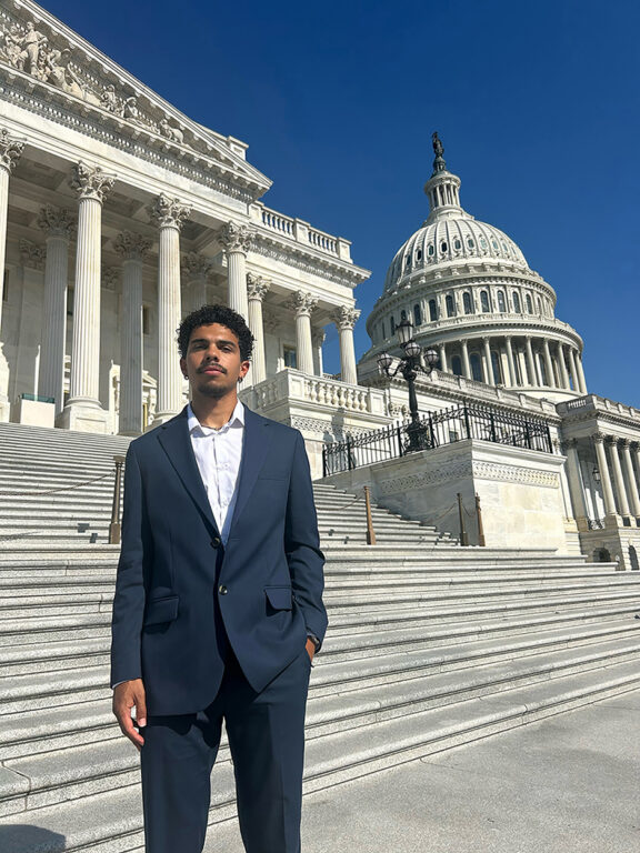 student standing on steps of US Capitol during internship