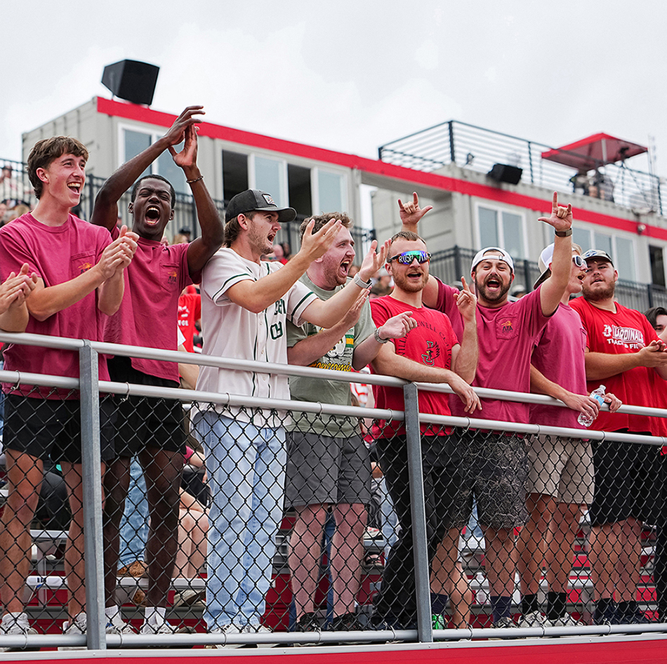 members of Lambda Chi fraternity cheering in stands at football game