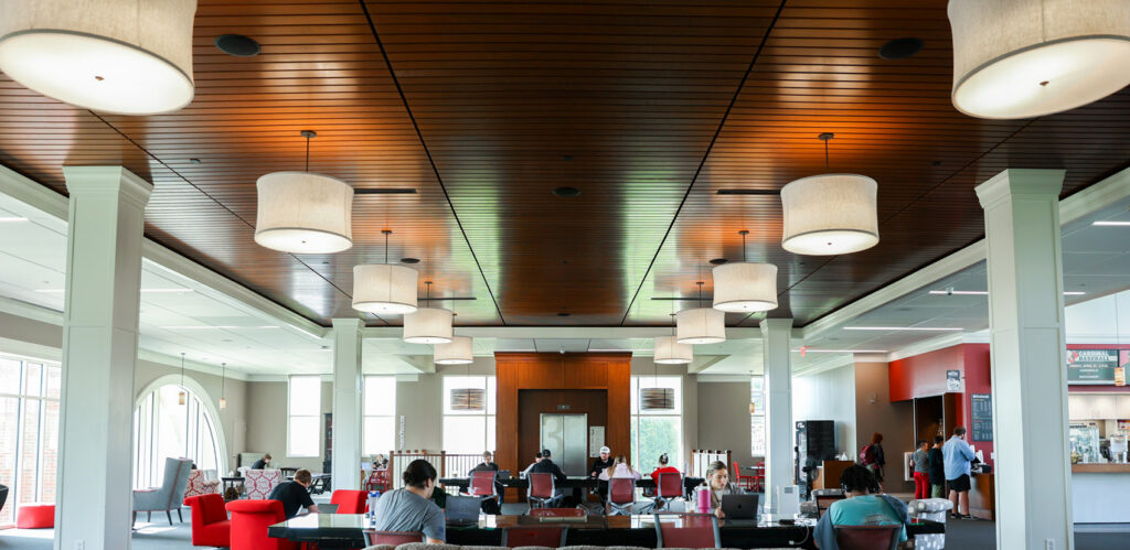students studying at tables in campus commons building