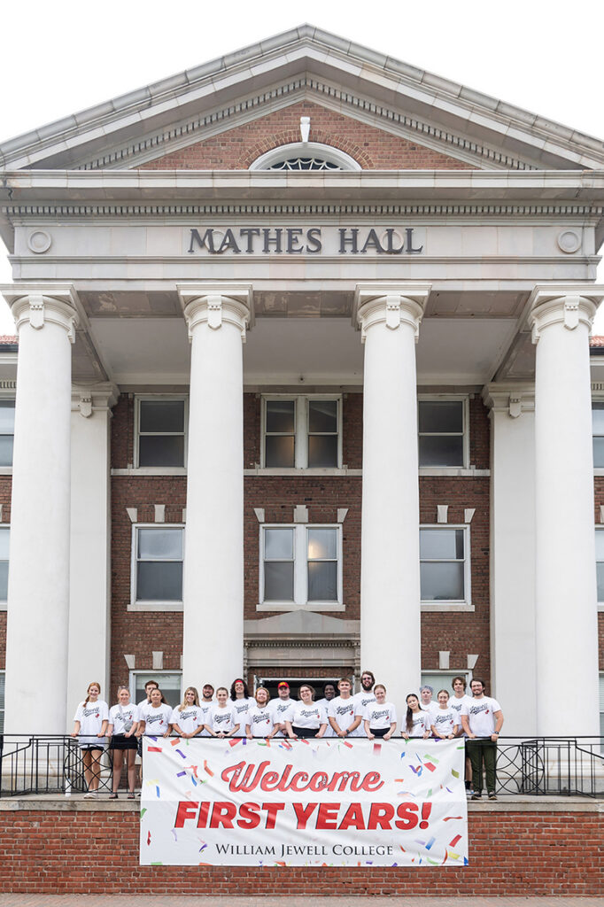 group of orientation leaders in white T-shirts standing behind sign reading WELCOME FIRST YEARS
