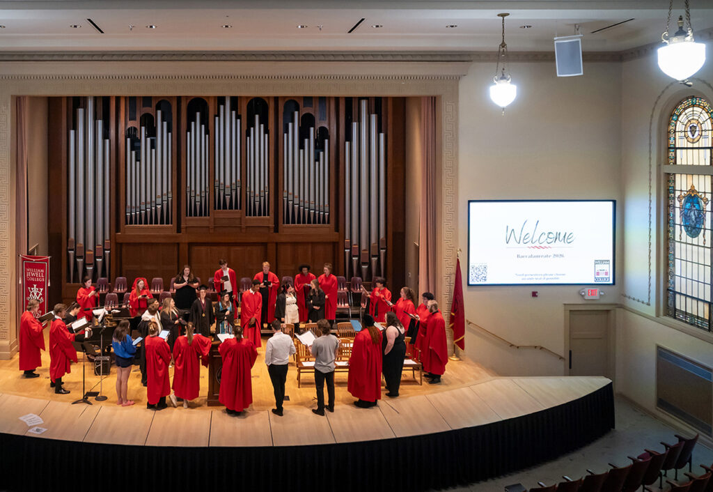students and baccalaureate participants in a circle on chapel stage