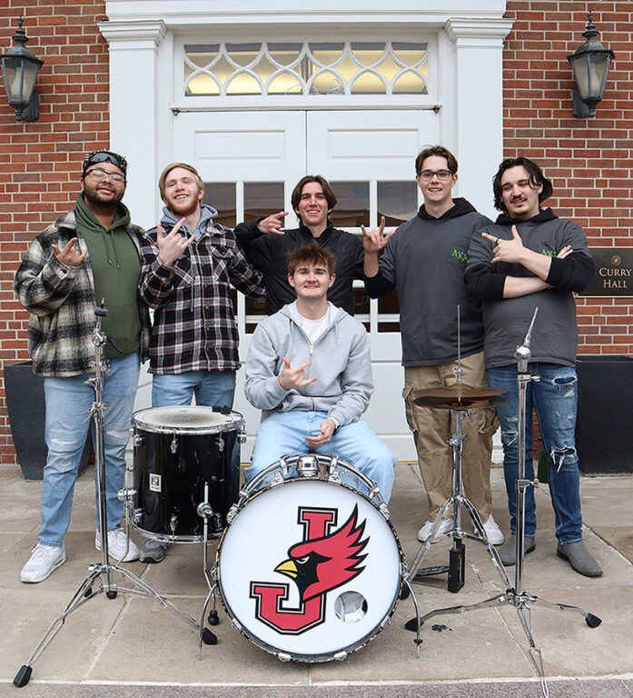6 member band posing on outdoor stage
