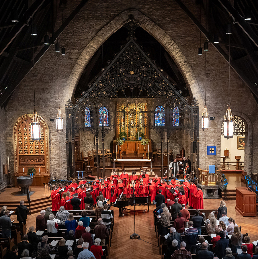 aerial of choir singing in front of large cathedral