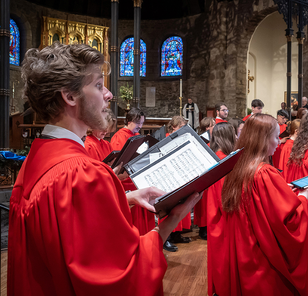 man in red choir robe singing with choir in KC cathedral
