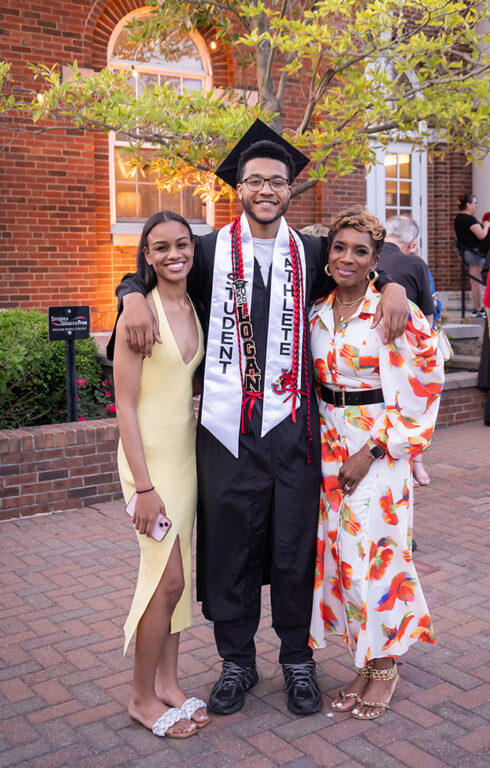 graduate posing outside with family