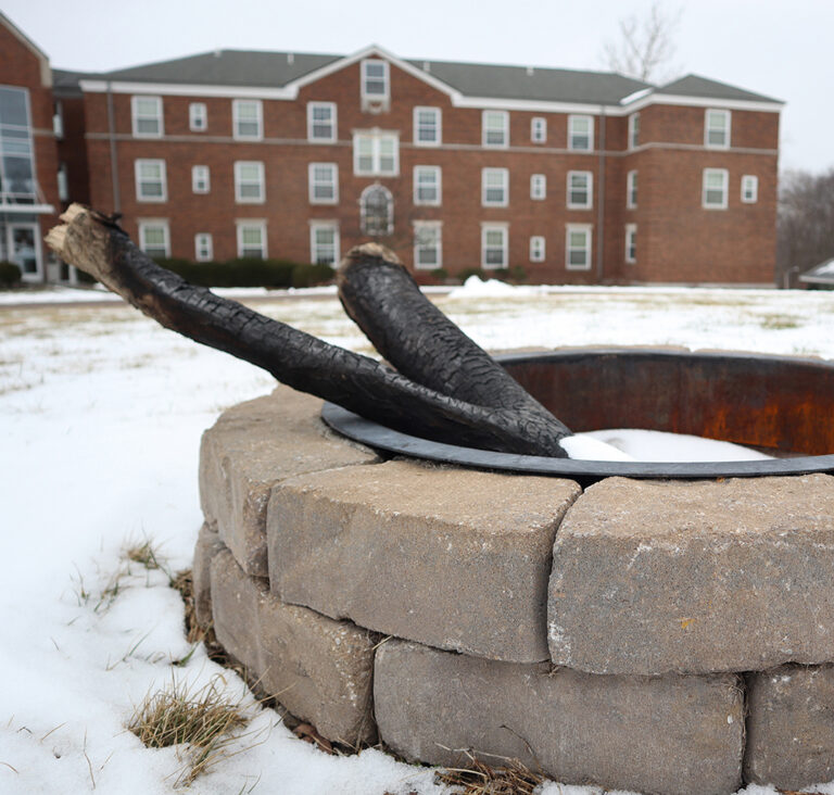 fire pit with Melrose Hall dorm in background