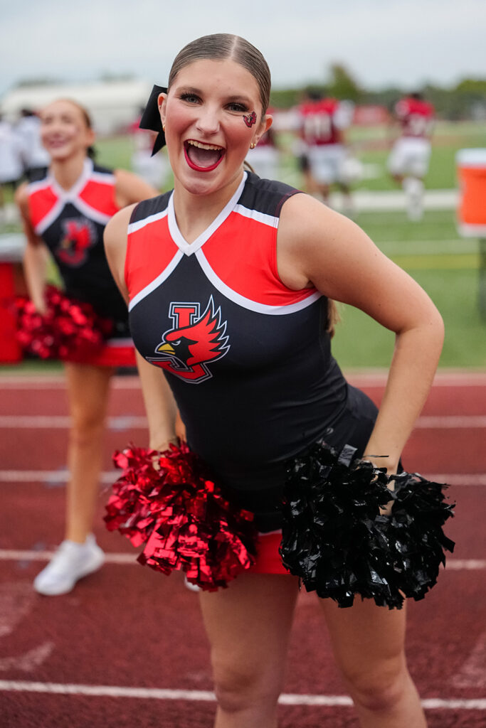 football cheerleader holding pom poms