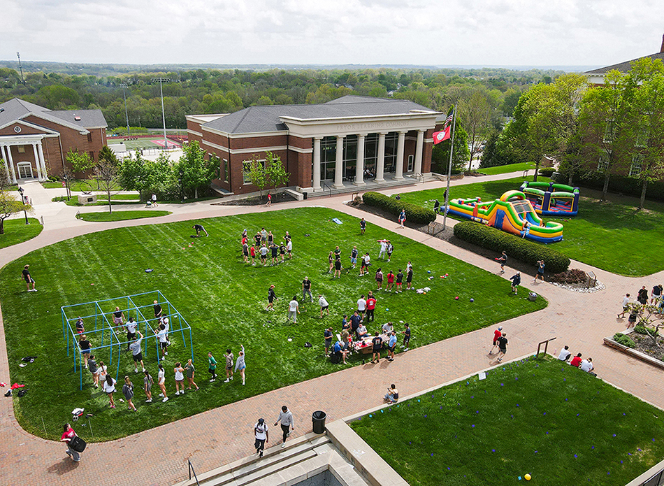 aerial of campus quad with inflatables and students playing games