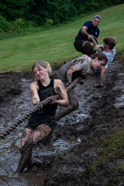student tug of war game in mud