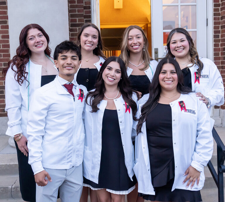 group of nursing majors in white coats after nursing pinning