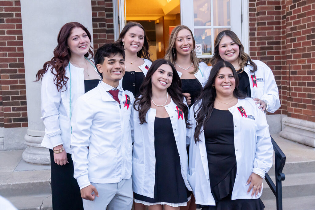nursing grads wearing white coats after pinning ceremony