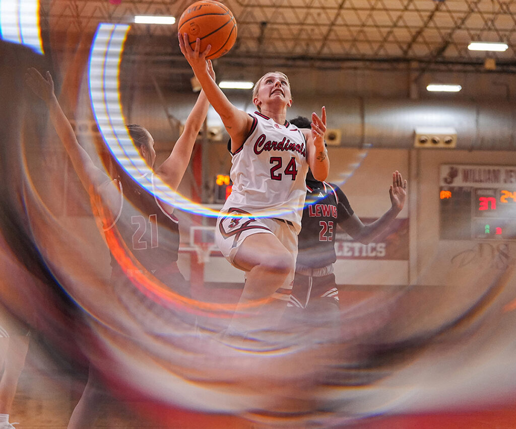women's basketball player shooting a layup at a game