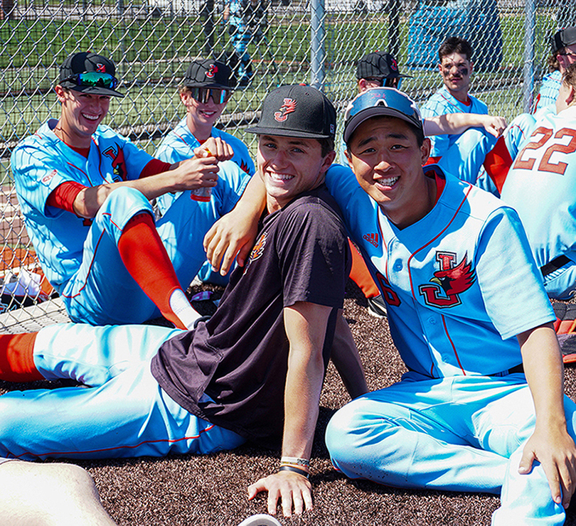 baseball players in uniform sitting on ground talking
