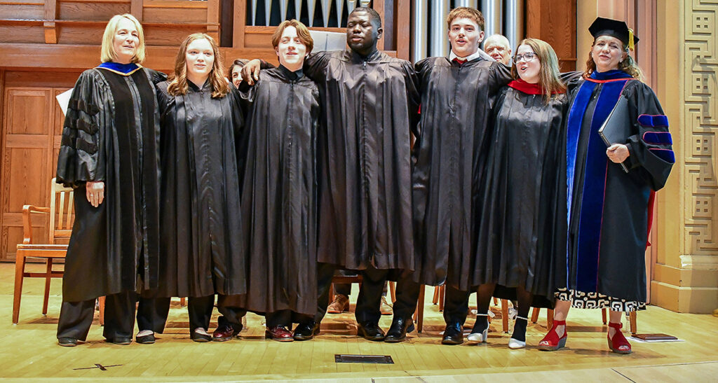top students on stage with faculty in regalia for honors convocation event