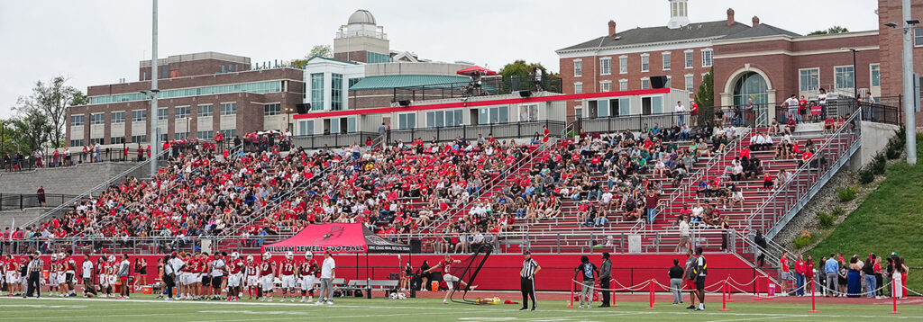 football stadium filled with fans wearing red at homecoming game